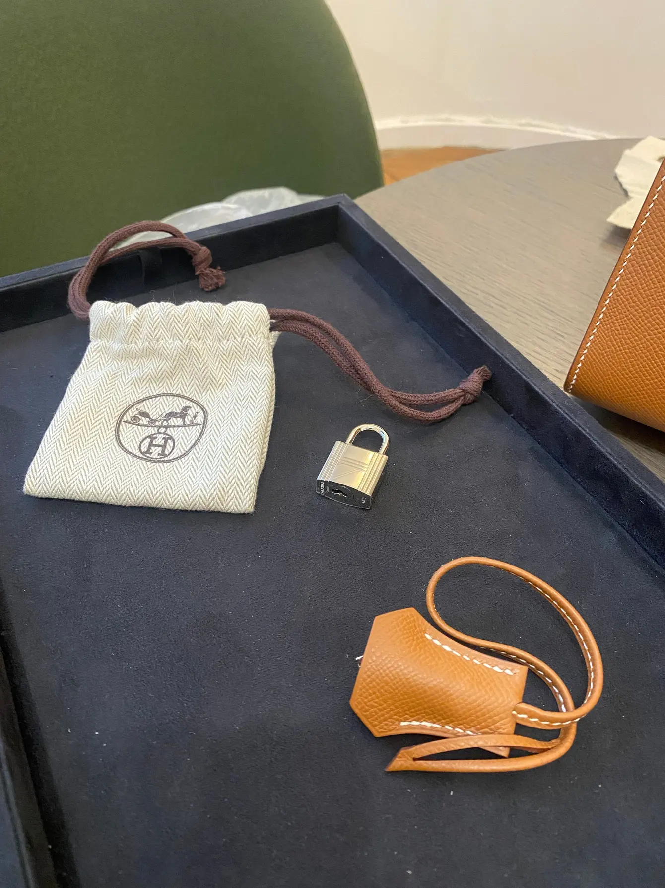 Plateau de velours bleu nuit, cadenas, clochette en cuir et pochette