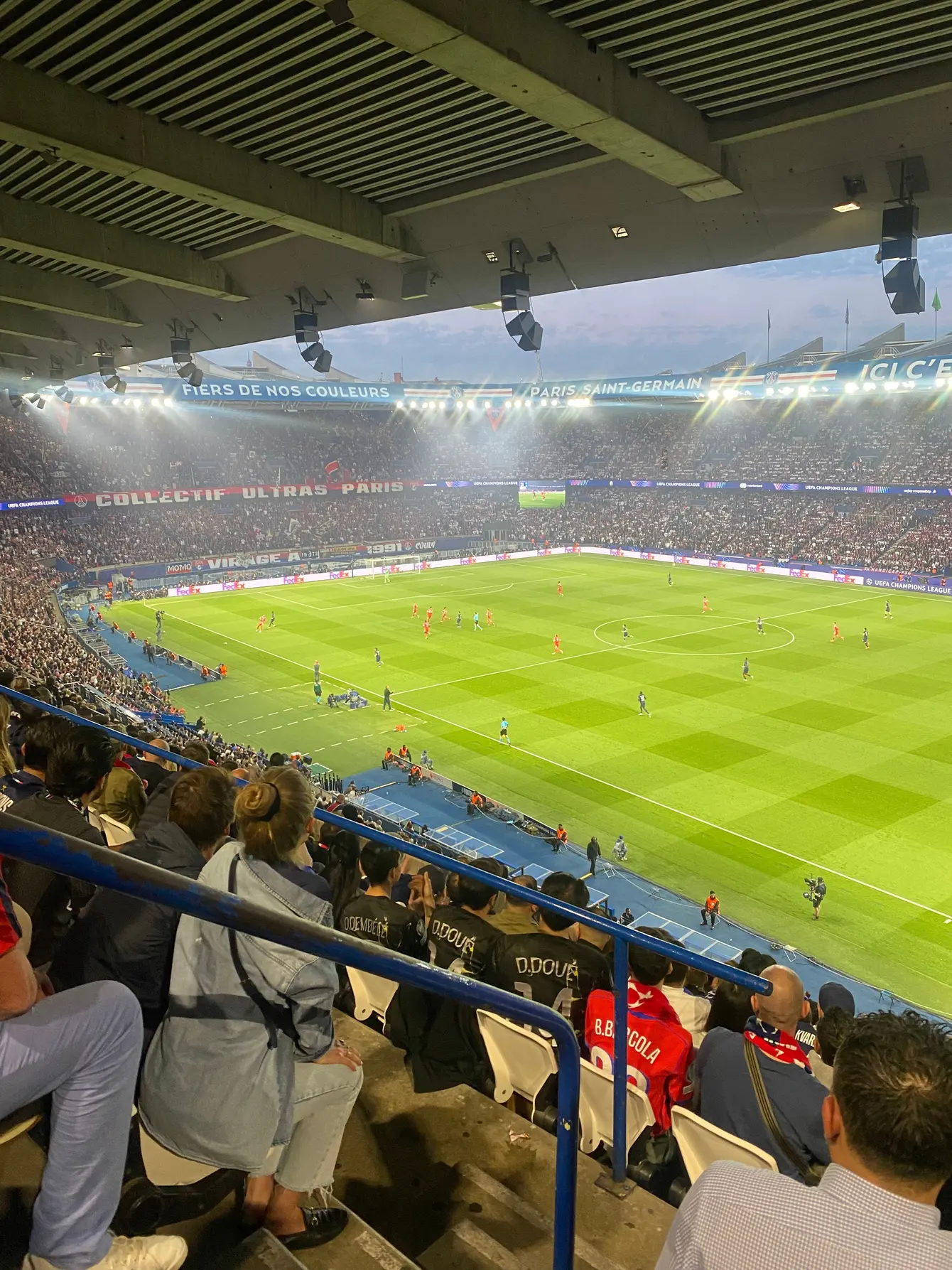 Vue d’une tribune sur un match de football en soirée
